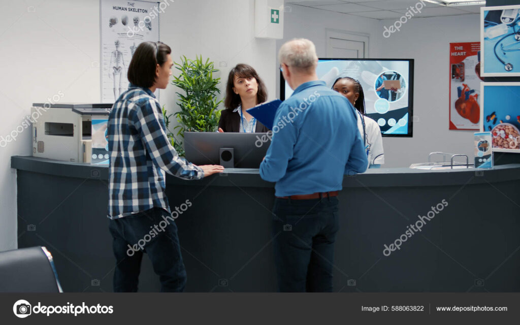 Busy hospital reception desk with many patients waiting
